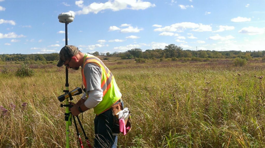 KL Engineering surveyor working in a field