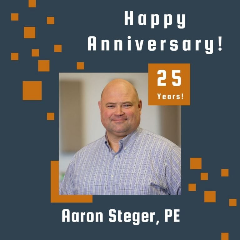 Photo of Aaron Steger framed by a navy background with orange scattered boxes and Happy Anniversary text.