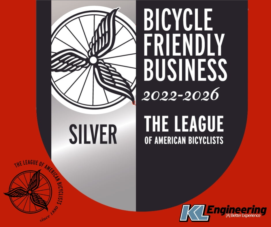 Bicycle Friendly Business logo from The League of American Bicyclists - black and silver on red background with KL logo.
