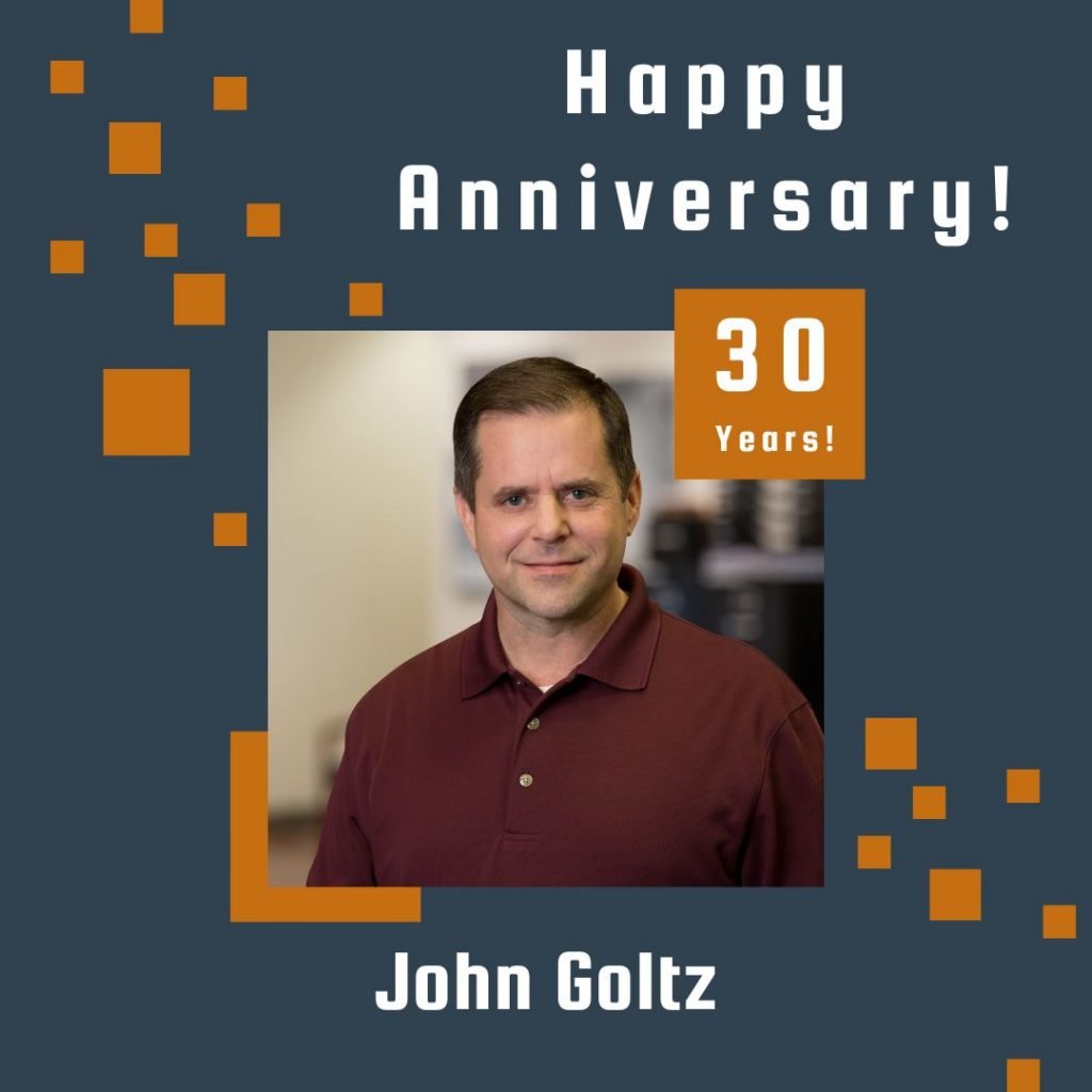 Photo of John Goltz framed by a navy background with orange scattered boxes and Happy Anniversary text.