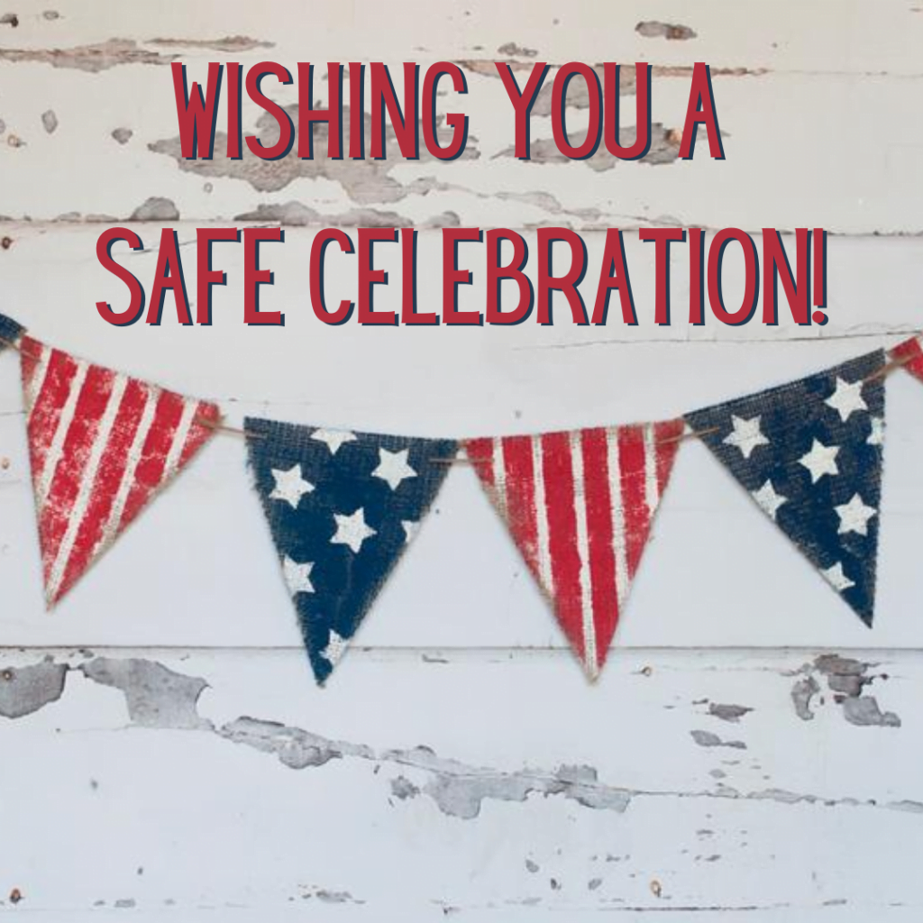 White wooden background with American flag decoration hanging and ‘Wishing you a safe celebration!’ text.
