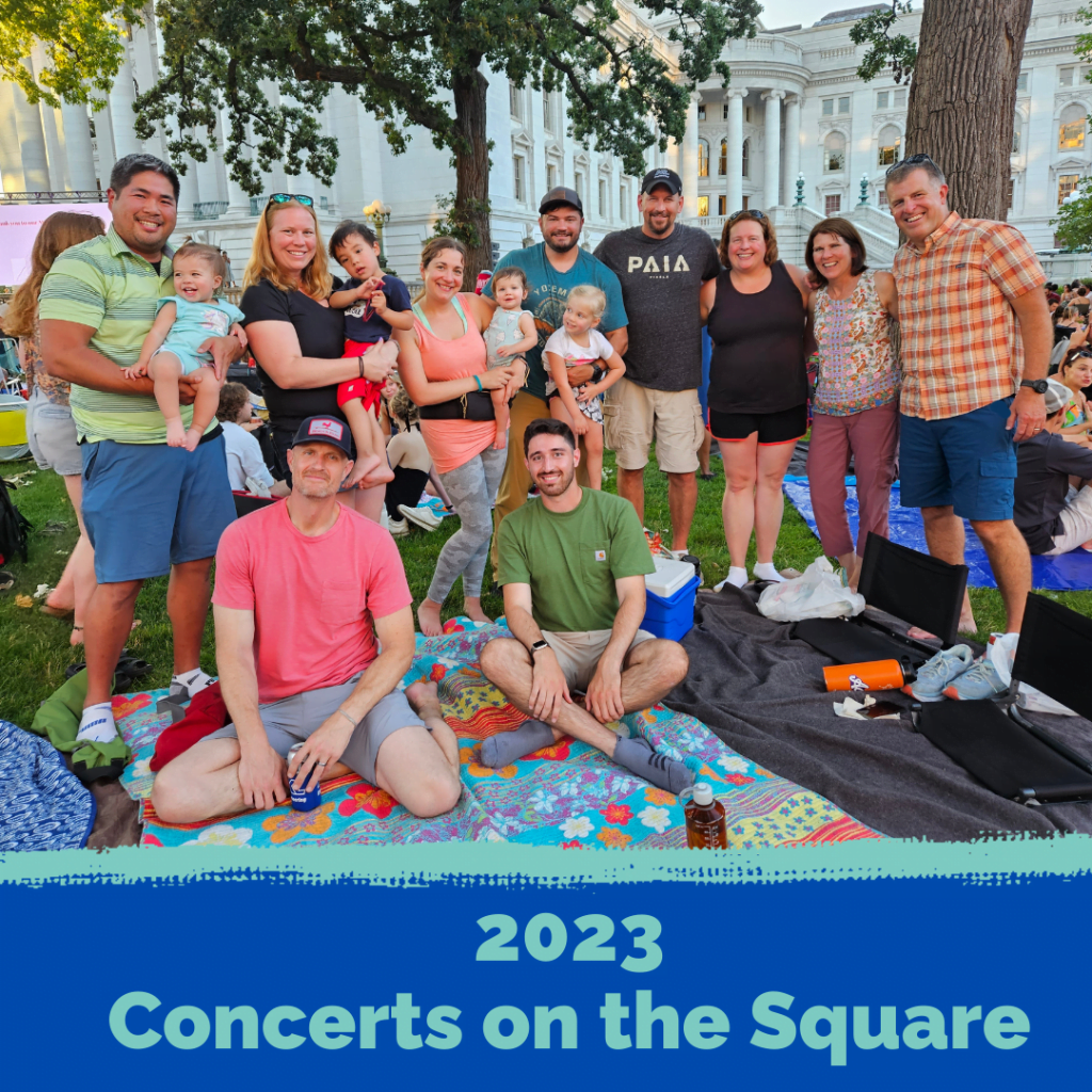 Smiling men, women, and children of all ages from KL Engineering in the park in front of the Wisconsin Capitol Building in Madison.