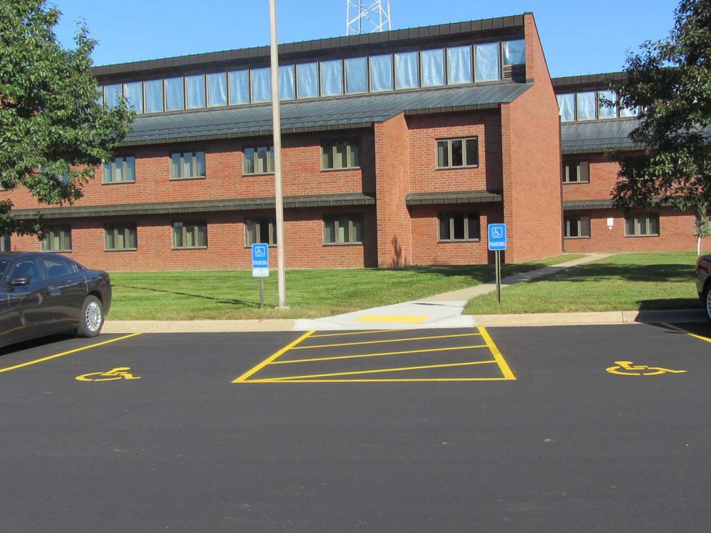 Image of new parking lot with handicap accessible parking spots and entrance to building.