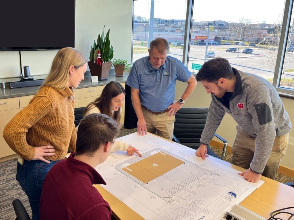 Site Development Team looking at plans in a conference room