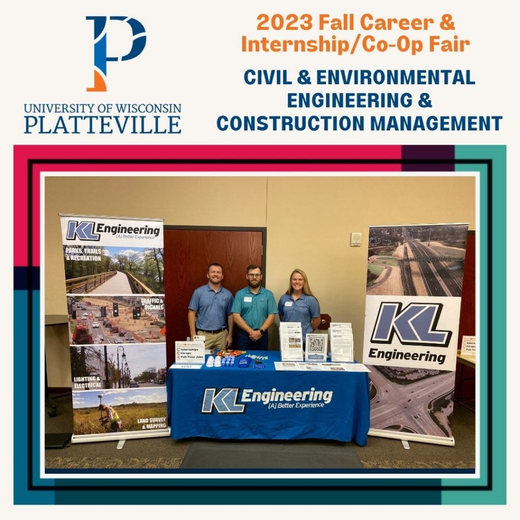 One smiling woman and two smiling men wearing KL Engineering shirts and standing behind a table with the KL Engineering logo. There are two large display boards with photos of transportation projects, highways, roads, and multi-modal pathways on either side of the table.