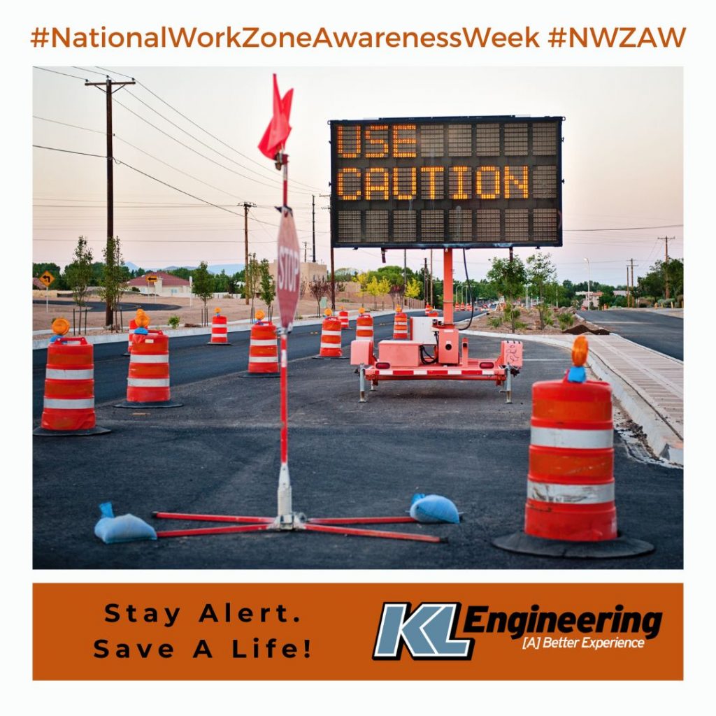 Photo of 'Use Caution' sign in a work zone with 'Stay Alert. Save A Life!' text in black on an orange box, KL logo, and #NationalWorkZoneAwarenessWeek #NWZAW text at top.