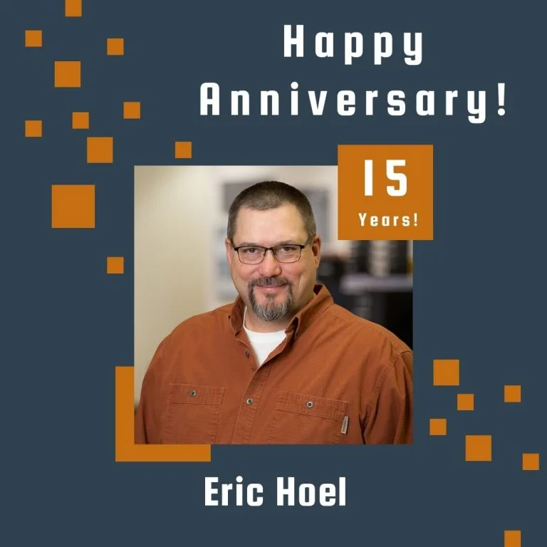 Photo of employee framed by a navy background with orange scattered boxes and Happy Anniversary text.
