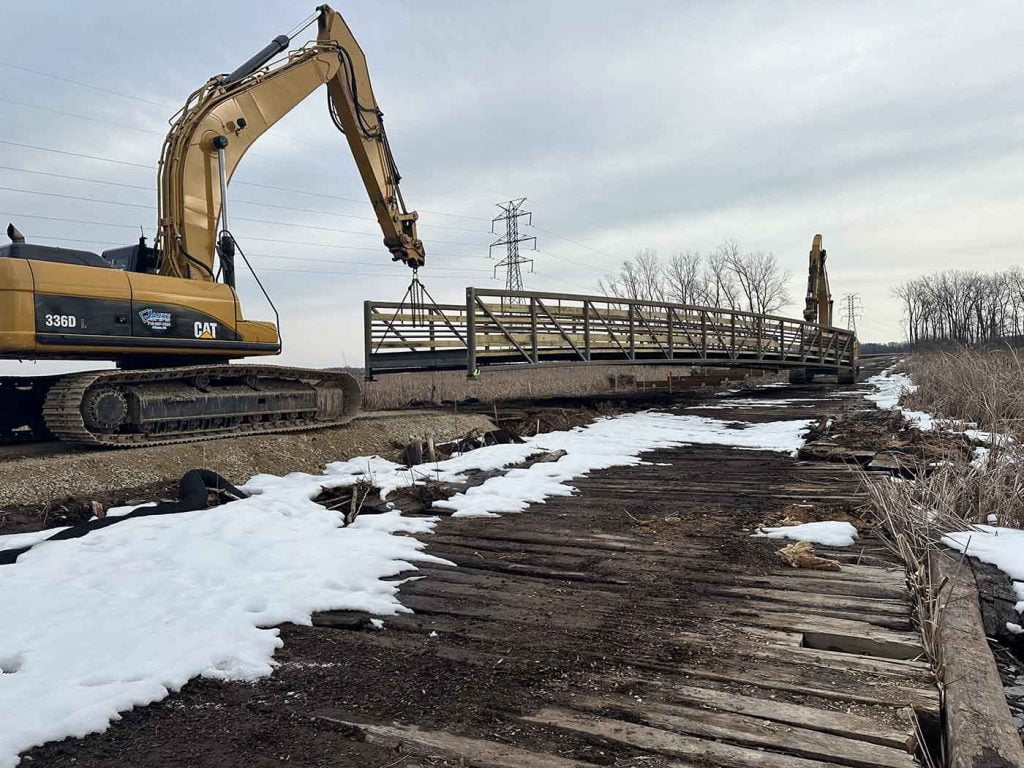 Lower Yahara River Trail P2 - Fish Camp County Park Improvements project photo of bridge being moved into place by two cranes.