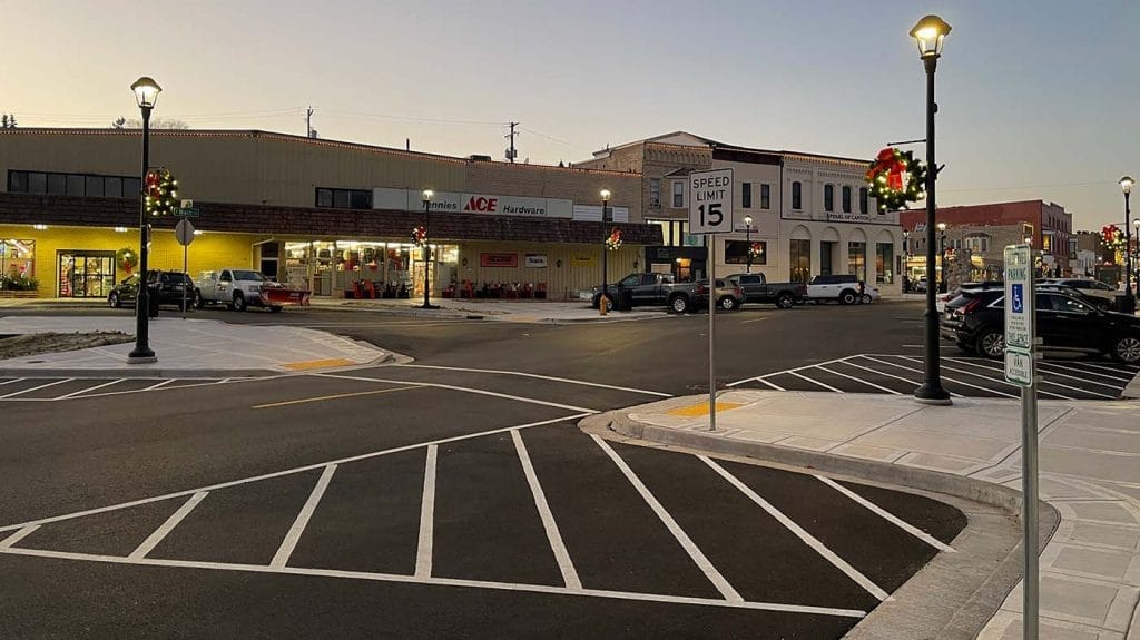 Photo of Main Street in West Bend, WI showing the new lights at night, decorated with holiday wreaths and new parking and pedestrian area