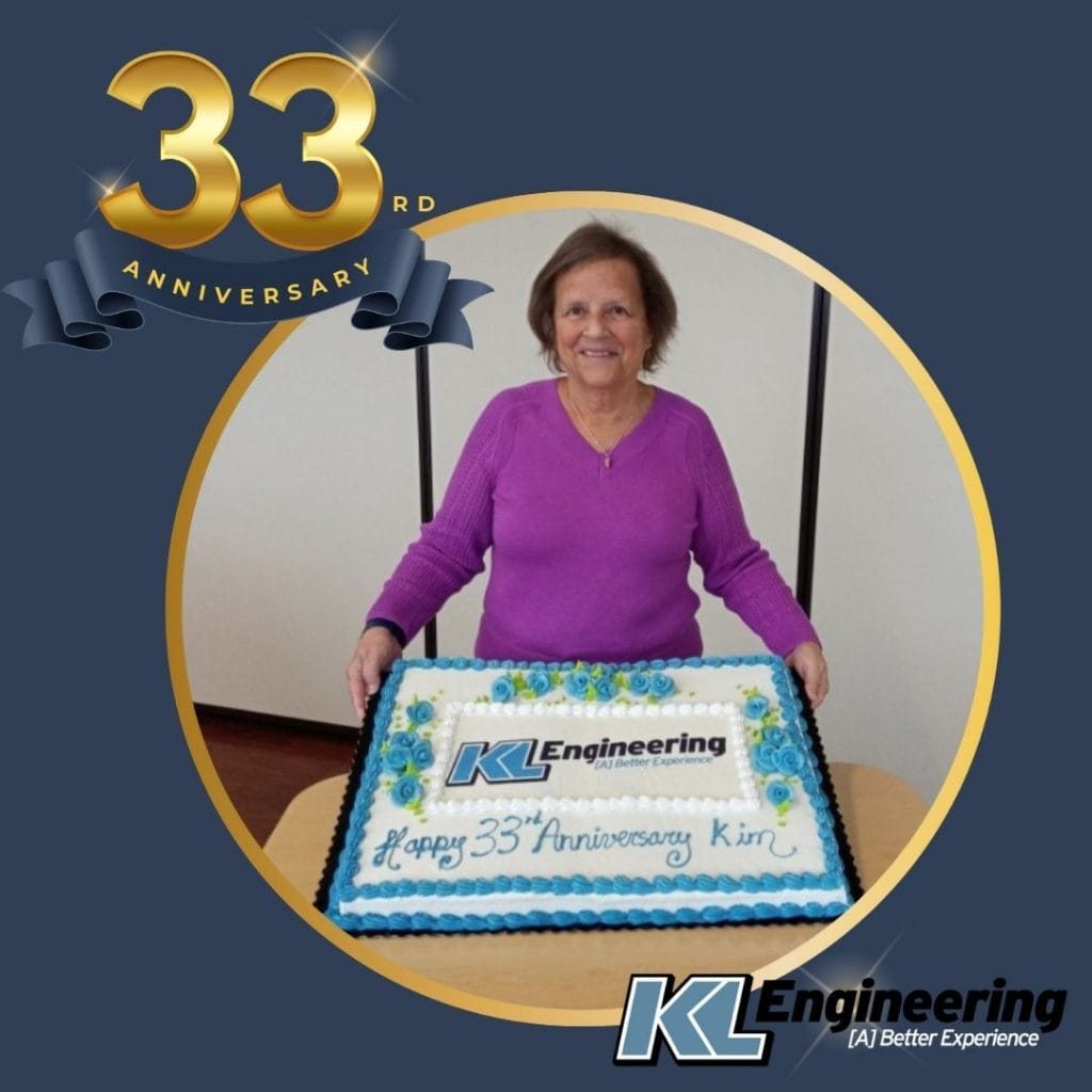 Golden 33rd Anniversary text with KL logo on a regal background with circular photo of Kim Lobdell holding celebratory cake.