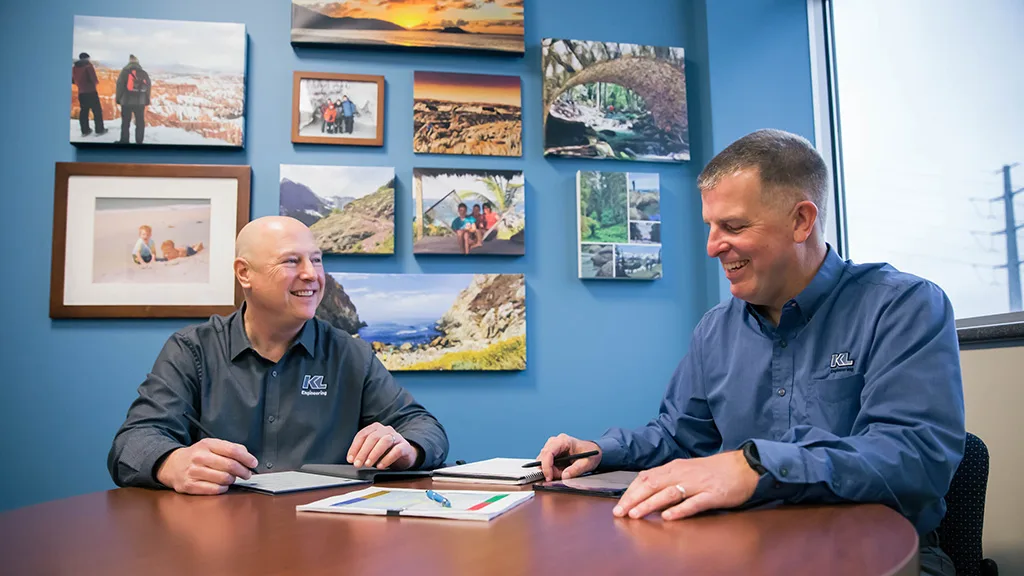 Photo of Ryan Schanhofer and Scott Cramer sitting at a table in Scott's office