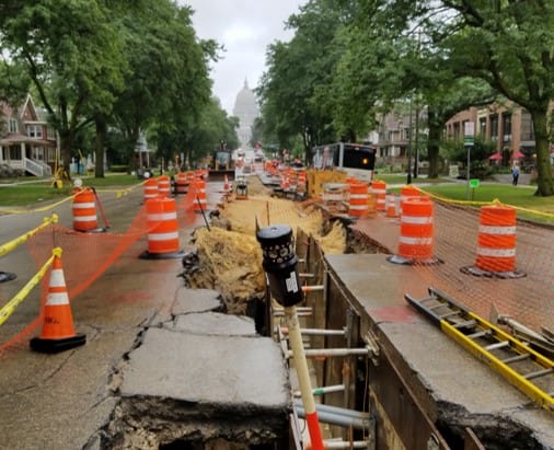 Photo of survey equipment in a construction zone on a street.