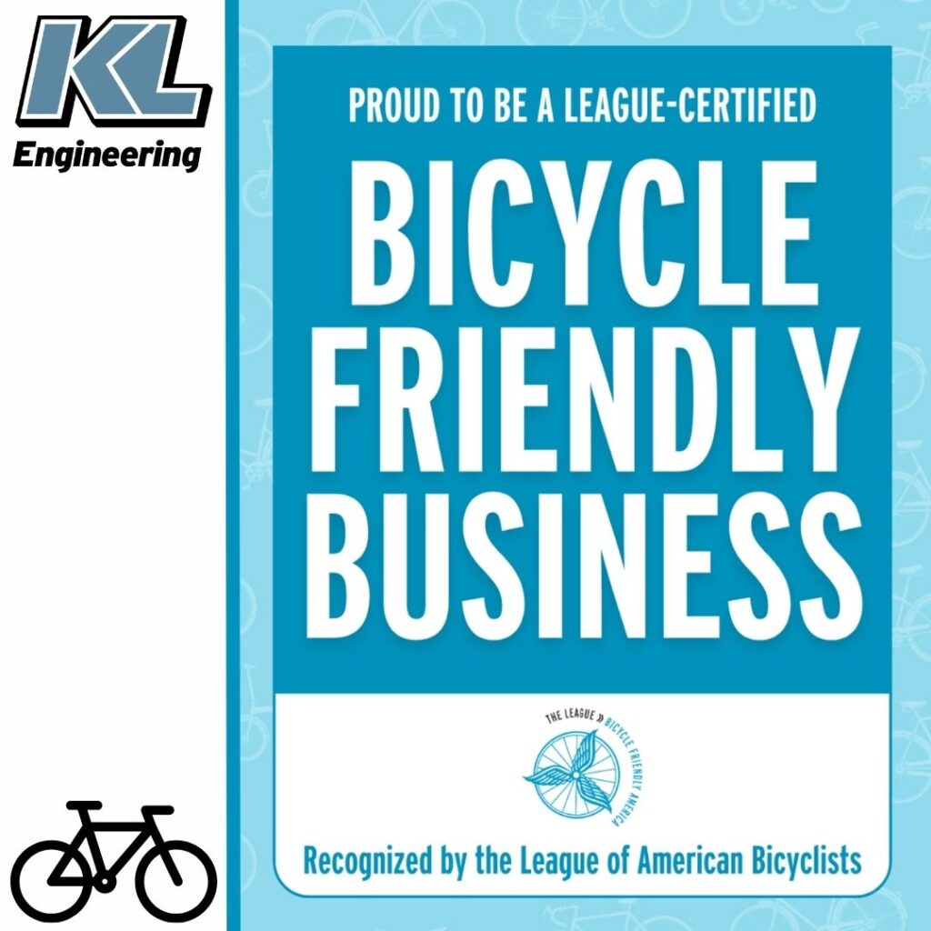 Graphic includes the text "Bicycle Friendly Business: with blue accents, and the KL logo in the top left corner with a small black outline of a bike in the lower left corner.