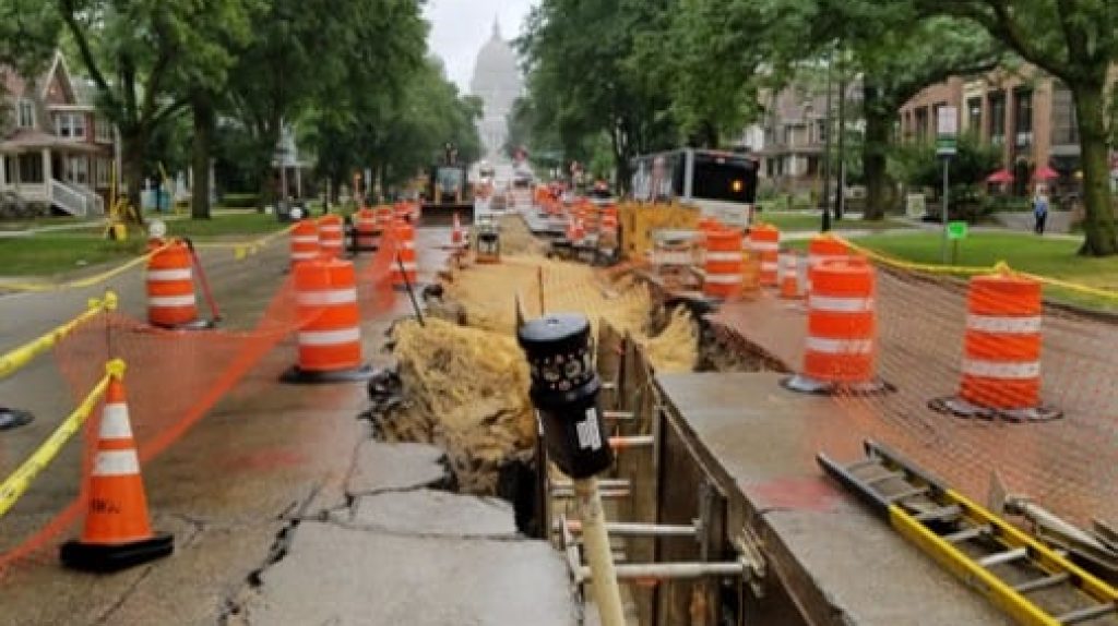 Photo of survey equipment in a construction zone on a street.